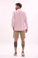 Camisa de vestir rosada de manga larga, con cuello clásico y cierre frontal con botones.