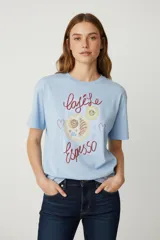 Remera celeste de algodón con estampado de tazas de café y texto en color rojo.