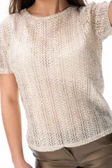 Blusa color dorado de tejido calado con mangas cortas y cuello redondo.