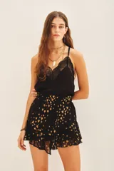 Minifalda negra con estampado de corazones dorados, cintura elastizada y volados en el ruedo.