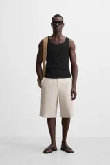 Musculosa negra ajustada al cuerpo, con cuello redondo y sisas amplias.