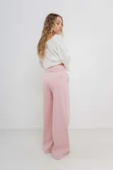 Pantalón de tiro alto, corte palazzo amplio y fluido, color celeste claro. Presenta bolsillos delanteros y traseros tipo jean, con logo metálico Peach en la parte posterior.