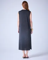 Vestido largo de tejido de punto color crudo, con textura metalizada, cuello escote en V y tajos laterales.