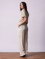 Pantalón cargo de lino color blanco, marca Marissa Olivia. Tiene pretina ancha elastizada con lazo de ajuste, bolsillos inclinados delanteros y bolsillos laterales con botón.
