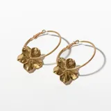 Aros tipo argolla dorados con dije de flor calada.