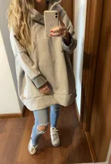Canguro gris de corte amplio con detalles en los puños, diseño casual y cómodo.