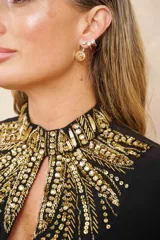 Aros dorados con circonitas blancas. Un aro es tipo cuff con tres circonitas y el otro es colgante con una circonita grande.