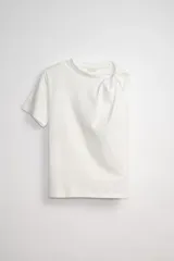Remera blanca de algodón con estampado asimétrico en el frente y detalle de nudo en el hombro.