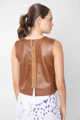 Chaleco corto marrón de cuero con cuello redondo y costuras a la vista.