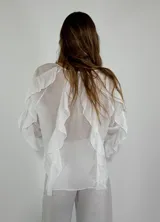 Camisa color rosa pálido con escote en V y volados en el frente y las mangas. Cierre con botones.