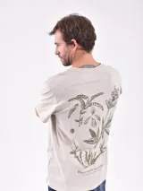 Remera color beige con estampado pequeño en el pecho.