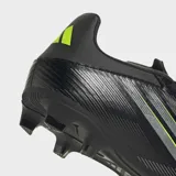 Championes de fútbol Adidas F50 Club para múltiples superficies, color negro con detalles en amarillo neón. Presentan un diseño con franjas diagonales y el número "F50" estampado en la puntera.