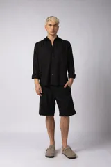 Camisa de manga larga color beige claro, con cuello abierto y calce relajado.