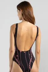 Traje de baño enterizo negro con estampado de cadenas y tigres rosas. Tiene escote cuadrado, breteles anchos y cinturón blanco con hebilla dorada en forma de tigre.
