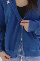 Campera con capucha color marrón con cierre frontal y logo de la marca en el pecho.