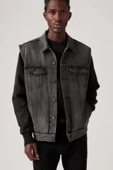 Chaleco de jean negro gastado, con cuello clásico, cierre frontal con botones metálicos, bolsillos con solapa en el pecho y corte recto.