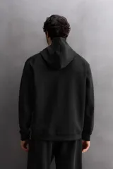 Sudadera con capucha color marrón topo, de corte regular fit, confeccionada en tejido técnico compacto de algodón con elasticidad. Cuenta con cuello subido, manga larga con bolsillo, bolsillos frontales con cierre de cremallera y acabados con rib del mismo tejido.