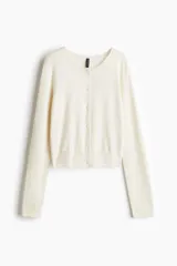 Cárdigan de punto fino color crema, con cuello redondo, botones frontales y mangas largas.