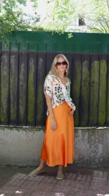 Falda midi evasé de raso color negro, con cintura elástica y cinturón con apliques metálicos.