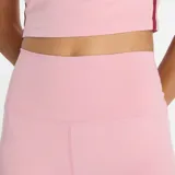 Calza deportiva de lycra color rosa, tiro alto, corte ajustado y largo a medio muslo. Incluye logo reflectivo de New Balance en la pierna izquierda.