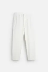 Pantalón blanco de algodón con textura, corte relaxed fit, cintura elástica ajustable con cordón, bolsillos laterales y traseros de vivo.