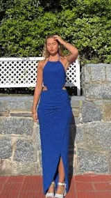 Vestido largo azul con escote halter, espalda descubierta y abertura lateral en la falda.