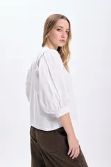Remera blanca de algodón con mangas cortas abullonadas de popelina.