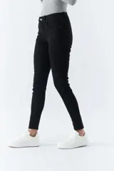 Pantalón de jean negro, corte skinny, tiro medio, con logo bordado y pasacinto.