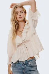 Jeans de denim azul claro con efecto lavado y desgaste sutil. Tienen un corte ajustado hasta la rodilla y luego se abren en un estilo acampanado (flare). Son de tiro bajo y presentan bolsillos delanteros abiertos y bolsillos traseros con solapa y botón.