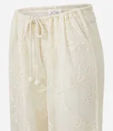 Pantalón de playa blanco de encaje floral con cintura elastizada ajustable con cordón.