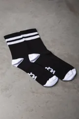 Medias deportivas negras con puntera y talón blancos, y dos rayas horizontales blancas en la parte superior.