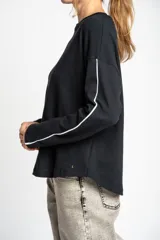 Sweater negro de algodón peinado con elastano, corte oversize y mangas largas con rayas blancas en los brazos.