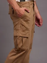 Pantalón cargo color marrón claro, corte skinny, con bolsillos laterales con fuelle y solapa.