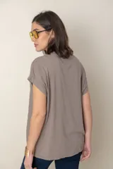 Blusa italiana color celeste con bordado de plumas al tono en el frente, confeccionada en lino y algodón.