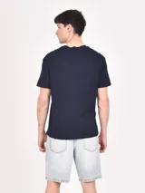 Remera azul oscuro de manga corta con estampado rectangular celeste y texto en blanco.