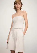 Short de vestir color crudo con finas rayas verticales, tiro alto, corte recto y bolsillos laterales.