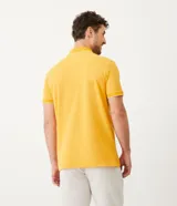 Polo de manga corta color amarillo, confeccionada en tejido de piqué con cuello clásico y tapeta de dos botones. Presenta ribetes blancos en cuello y mangas.
