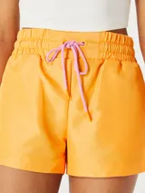 Short deportivo color naranja con cintura elástica y cordón ajustable rosa.