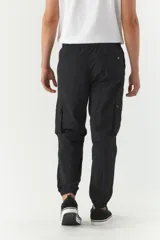 Pantalón cargo negro de nylon con cintura ajustable y puños.