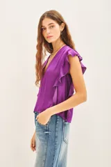 Camisa manga corta color violeta con escote en V y volados en sisas y laterales.