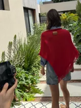 Poncho tejido en hilo de algodón con lurex color negro y dorado, con flecos en el ruedo.