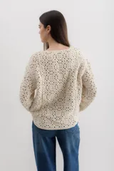 Sweater color crudo de tejido crochet con mangas largas.