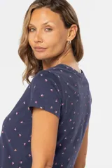 Remera de manga corta color gris claro con estampado de pequeñas figuras geométricas en azul.