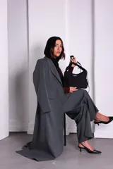 Bolso negro de nylon con textura sutil y manija fruncida.