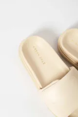 Sandalias negras con plataforma y tira ancha acolchada sobre el empeine.