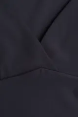 Top corto negro de punto interlock, ajustado al cuerpo, con escote corazón pronunciado y mangas japonesas. Presenta costuras moldeadoras frontales.