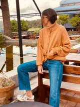 Cárdigan tejido color tostado, de lana, con cuello redondo y abotonadura frontal.