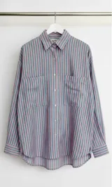 Camisa de manga larga con rayas verticales rosas y celestes, cuello clásico, cierre frontal con botones y dos bolsillos de parche en el pecho.