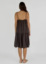 Vestido corto color marrón, con breteles finos, escote recto y corte holgado con volados en el ruedo.