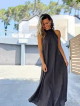 Vestido largo negro de lino, con escote halter que se ajusta al cuello y falda amplia con mucho vuelo.
